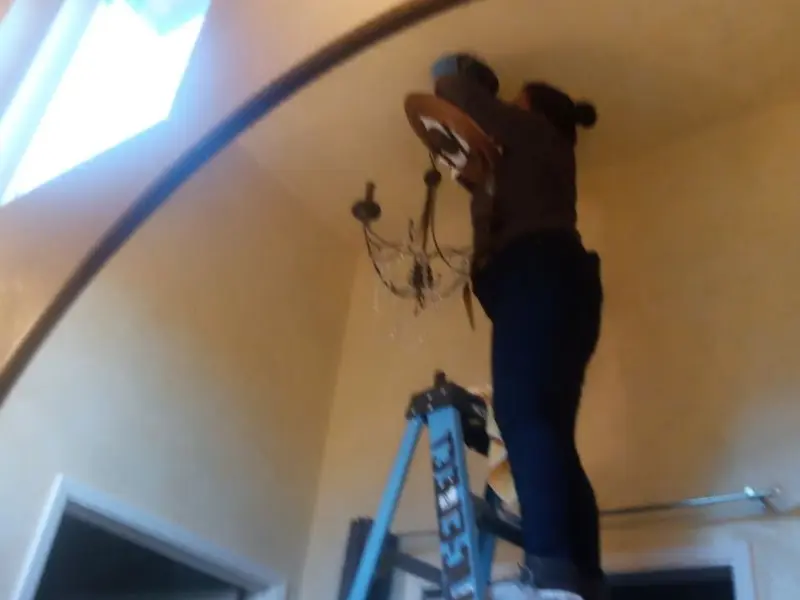 Electrician installing a chandelier in a Altadena residence